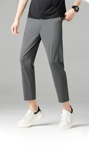 Detail of dark grey slim fit straight leg trousers paired with white sneakers