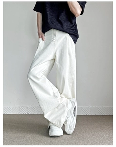 Dettaglio dei jeans bianchi a gamba larga a vita alta con finitura stile street cleanfit