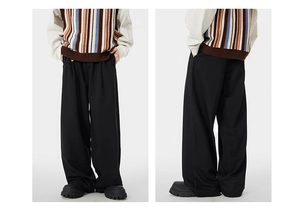 Macro shot of black wide-leg trousers showing drape texture and high-waist pleated details