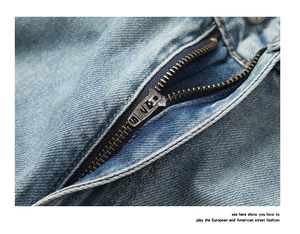 Détail d'un jean bleu clair montrant la fermeture éclair YKK en métal et la texture