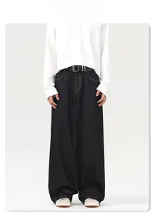 Detail view of dark indigo wide-leg jeans with a black leather belt and silver metal buckle