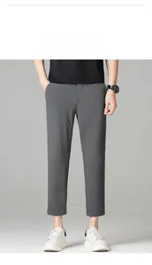Detail view of grey slim-fit cropped dress pants with professional straight-cut drape