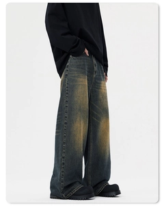 Detailansicht aus schwerem Vintage-Denim mit gelber Sandstrahl-Waschung und Distressed-Look