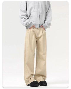 Macro shot of khaki pleated wide-leg trousers showing cotton twill fabric and loose fit cut