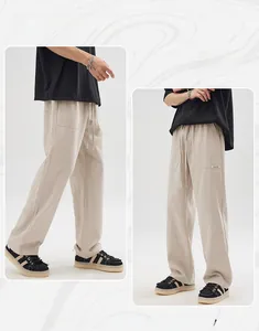 Detail view of khaki cotton linen trousers featuring elastic drawstring waist and side pockets