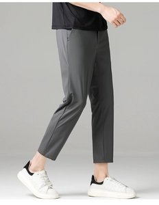 Detail view of dark grey slim fit business trousers showing smooth drape and side pocket