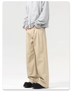 Detail view of khaki pleated cargo pants featuring high-density twill and a wide-leg silhouette
