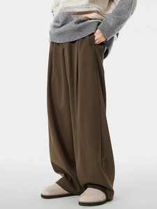 Dark brown wide-leg trousers in a loose fit, paired with a cozy knit sweater and clogs