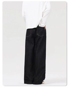 Rear view of deep blue wide-leg jeans featuring orange stitching and back pockets