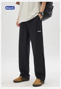 Detail of black linen-texture casual pants with drawstring waist and pocket label