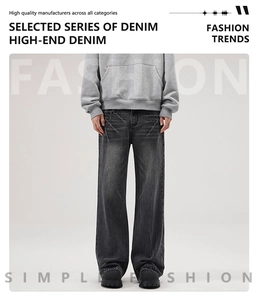 Detail of washed dark grey wide leg denim jeans featuring vintage whiskers and textures