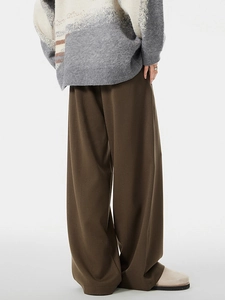 Men's dark brown wide-leg trousers with draped twill fabric shown from back view