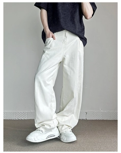 Dettaglio dei pantaloni larghi bianchi con taglio cleanfit e trama in cotone resistente