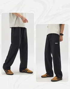 Detail view of black casual pants showing side pocket with small label and drawstring waist
