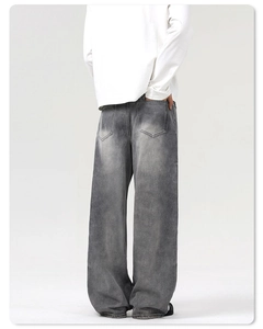 Détail du jean délavé gris foncé avec poches arrière et coupe large décontractée