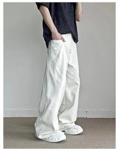 Dettaglio dei pantaloni larghi bianco sporco con cuciture laterali verticali uniche