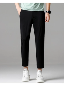 Detail view of men's slim fit black cropped trousers with stylish white sneakers