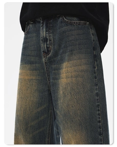 Detail von Vintage-Denim in Dunkelblau mit gelber Waschung und Cat-Washes am Bein