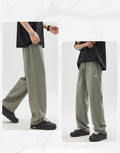 Detail of olive green casual linen pants featuring elastic waistband and side patch pocket