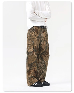 Detail of cargo pants with branch camouflage pattern and black leather belt accessory
