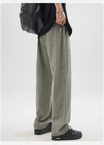 Detail of grey-green cotton-linen trousers showing texture and Collection fabric label