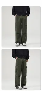 Vista dettagliata dei pantaloni cargo verde scuro con ampie tasche laterali e gamba larga