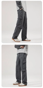 Dettaglio dei pantaloni cargo grigio scuro con tasche laterali a patta e taglio dritto