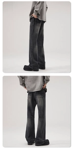 Detail view of washed black wide-leg denim jeans with vintage snowflake texture and stitching