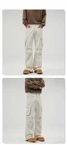 Detail view of cream white cargo pants showing large flap pockets and twill cotton texture