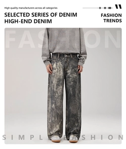 Detail of acid-wash ink splatter pattern on heavy loose-fit wide-leg denim jeans