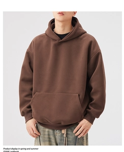 Detail of heavy brown hoodie showing front kangaroo pocket and ribbed cuffs in studio