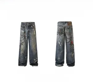 Detail view of heavy-washed denim pants featuring rusty chains and paint splatter prints