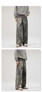 Detail view showing heavy washed ink-splatter jeans in loose-fit wide-leg denim style
