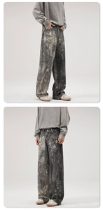 Detail of loose-fit men's jeans with vintage faded tie-dye and distressed textures