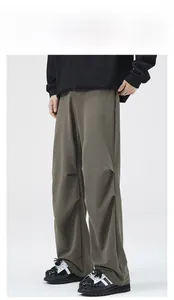 Detailed view of olive green loose knit trousers featuring premium draped texture and cut