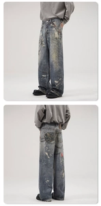 Detail view of vintage loose jeans with distressing, paint splatters and chain embroidery
