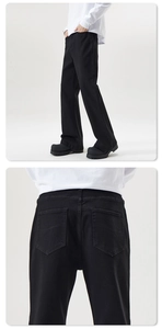 Detail view of double W-shaped stitching on rear pockets of black slim-fit flare jeans