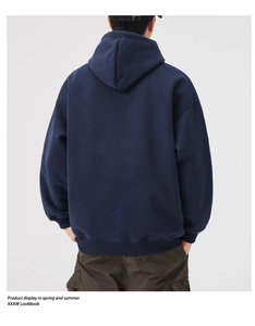 Back view of a loose-fit navy blue hoodie paired with brown cargo pants in studio