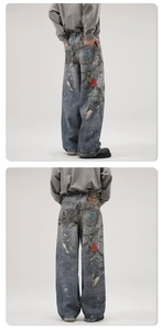 Detailed back view of distressed loose denim pants with embroidery and chain accents