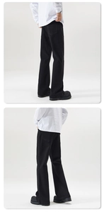 Detail view of black high-street wide-leg trousers showing drape and relaxed fit from behind