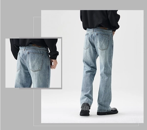 Detail of light blue denim jeans with washed effect and brown leather waist patch
