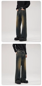 Detail view of vintage dirty wash denim flare pants with distressed yellow tint effects