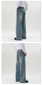 Detail view of baggy washed denim jeans showing back pocket and leather waist tag