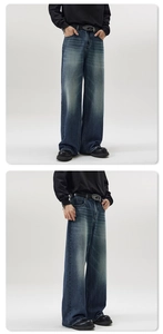 Close-up of vintage washed wide-leg jeans with metal buckle belt and relaxed silhouette