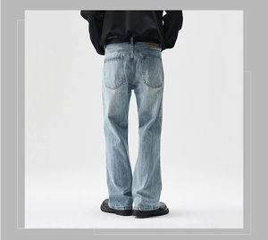 Detail view of men's vintage light blue washed flared jeans with leather back waist patch
