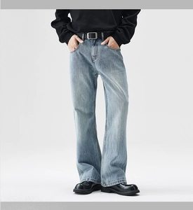 Detail of light blue flared jeans for men with vintage wash and classic five-pocket style