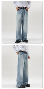 Close-up of washed light blue wide-leg jeans with vintage texture and metal belt detail