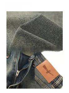 Vue détaillée du denim délavé rétro, de la fermeture éclair et de l'étiquette en cuir