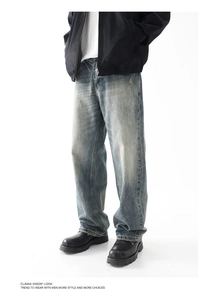 Dettaglio dei jeans a gamba larga azzurri con lavaggio vintage e trama baffata