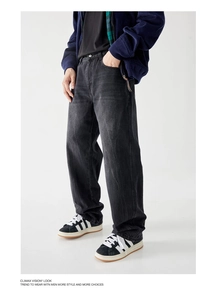 Detail view of washed black denim pants with lightning texture and straight fit design